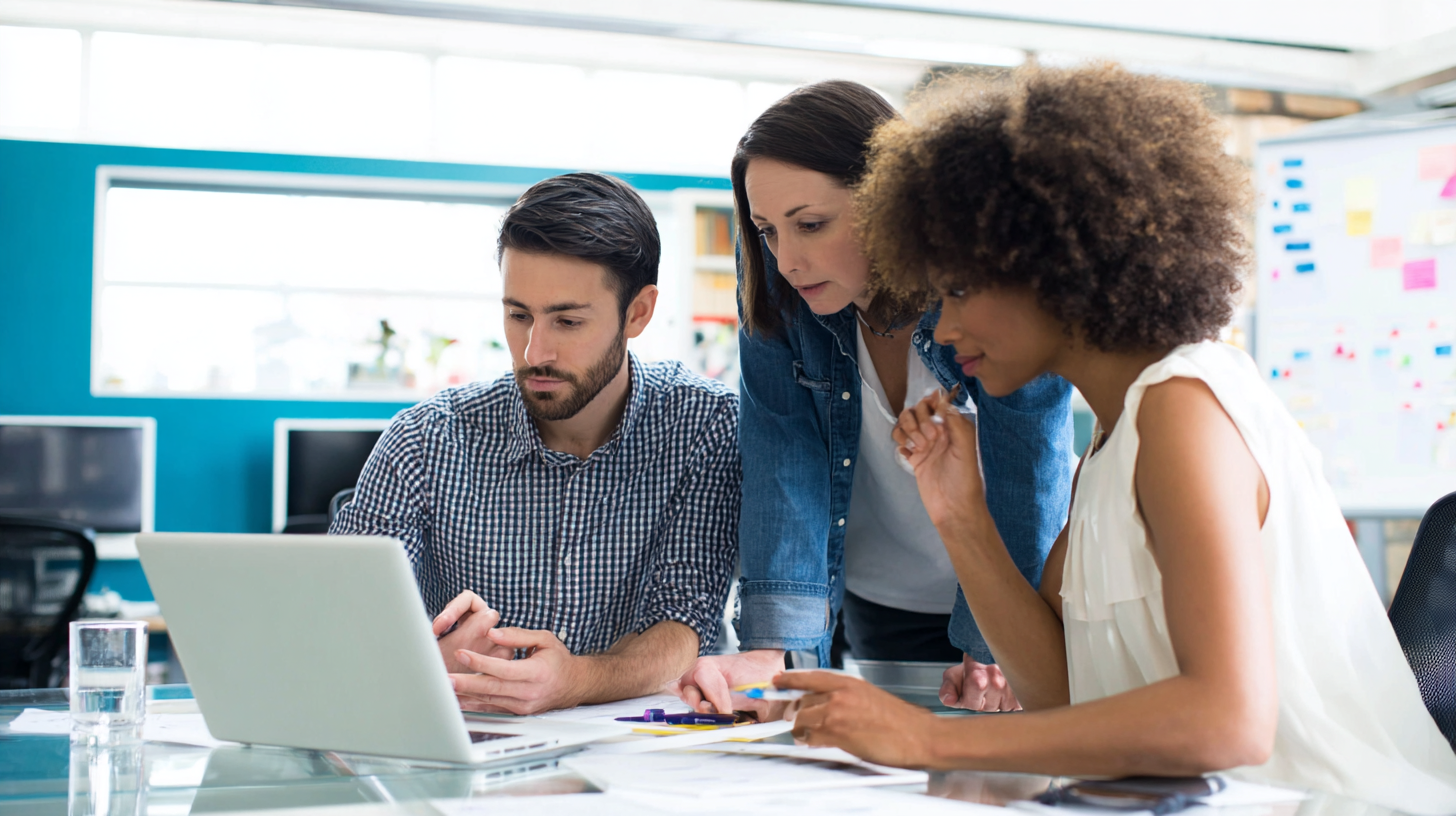 Small team workshop focusing on a laptop